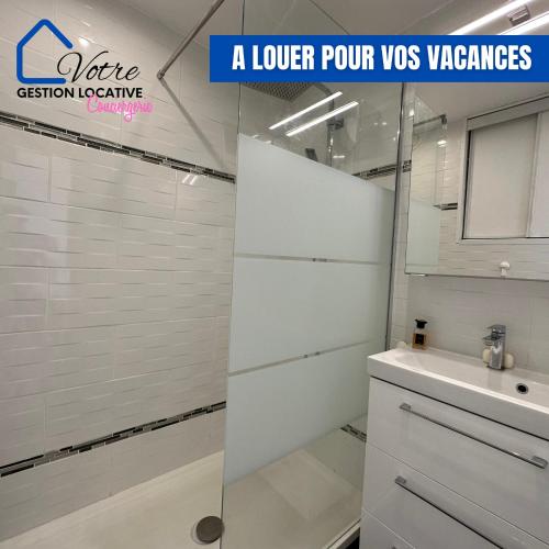 une salle de bain blanche avec un lavabo et un miroir dans l'établissement Appartement vue mer 4 couchages, à Canet