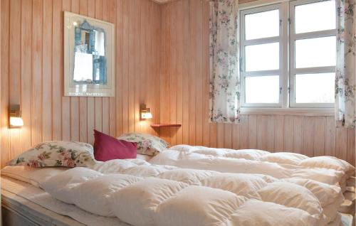 Stunning Home In Hvide Sande With Kitchen في Nørre Lyngvig: سرير أبيض كبير في غرفة بها نافذتين