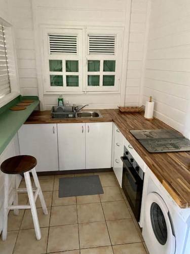 Una cocina con encimera, fregadero y estufa. en Kaz’Ary, en Sainte-Anne
