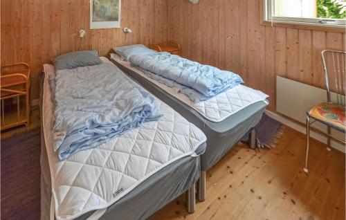 two beds in a room with wooden walls at Beautiful Home In Egernsund With 3 Bedrooms, Sauna And Wifi in Egernsund