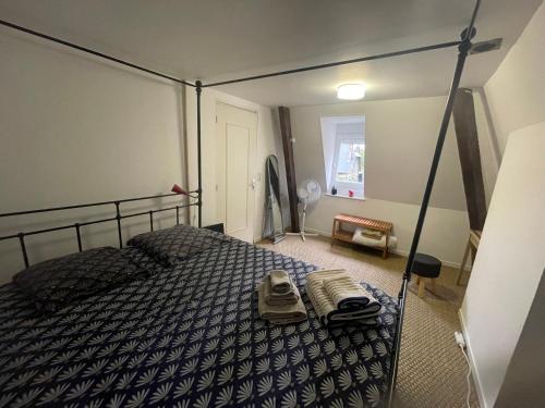 ein Schlafzimmer mit einem Bett mit Schuhen drauf in der Unterkunft Chambre privée cosy in Noyon