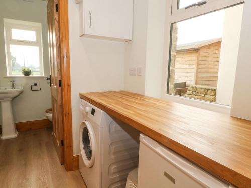 a laundry room with a washing machine and a window at Oak Tree View in Preston