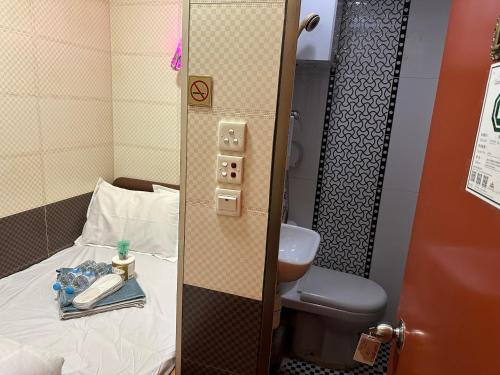 a small room with a bed and a toilet at Piaget guest house in Hong Kong