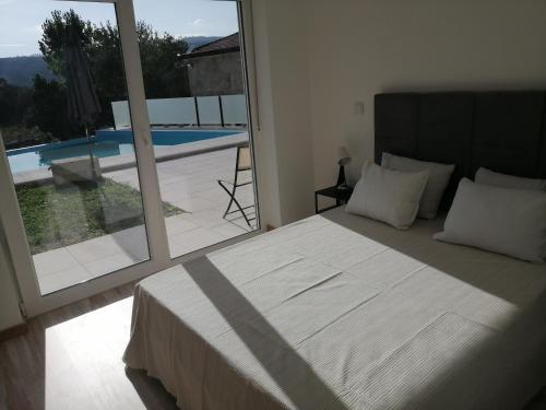 1 dormitorio con cama y vistas a la piscina en Chalé dos Beirais en Marco de Canavezes
