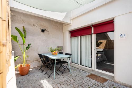 a patio with a table and chairs and a window at Bombarda Homes in Porto