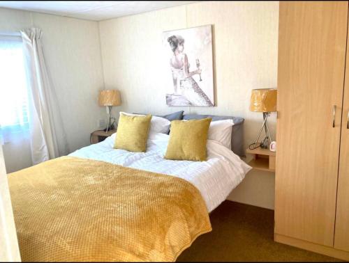 a bedroom with a bed with yellow pillows at Julie’s retreat in Abergele