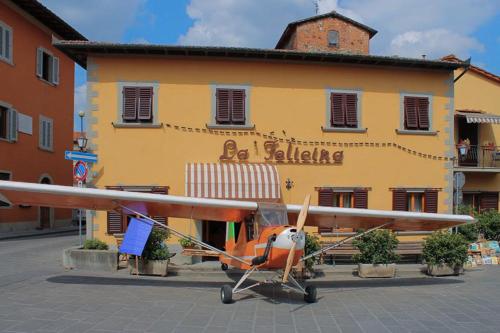 un piccolo aereo parcheggiato di fronte a un edificio di Albergo La Felicina - Mugello a San Piero a Sieve