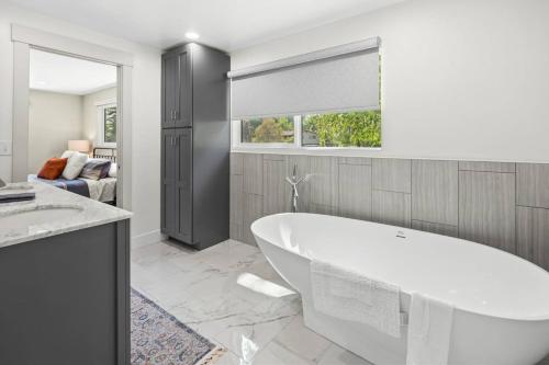 a white bathroom with a tub and a window at Pimlico Pastures in Eagle