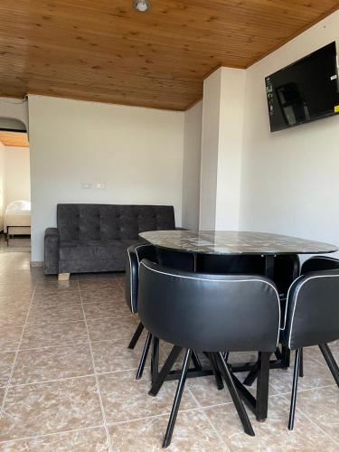 comedor con mesa, sillas y sofá en Acogedor Apartamento céntrico I, en Armenia