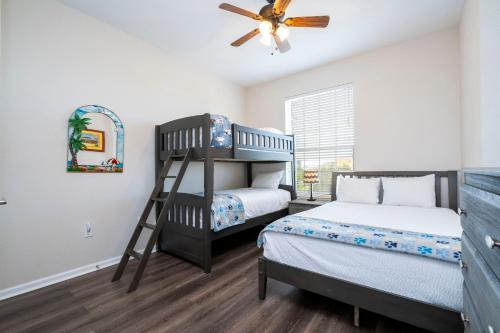 a bedroom with two bunk beds and a ceiling fan at The Best Location! Resort Near All Parks! Int'l Dr in Orlando