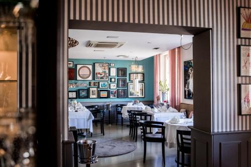 a dining room with white tables and chairs at Romantikhotel Rebstock art & design in Kehl am Rhein