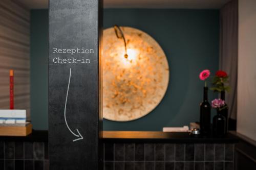 Romantikhotel Rebstock art & design في كيهل آم راين: ساعة على الحائط في الحمام