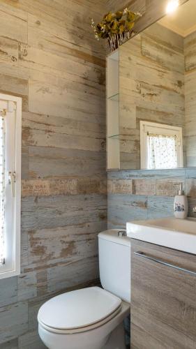 a bathroom with a white toilet and wooden walls at Mijas Beach House Parking in Mijas Costa