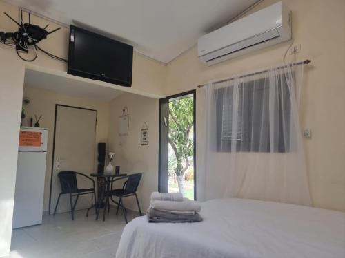 a bedroom with a bed and a table with chairs at B&B Amit 18 minutes from the airport - אירוח כפרי עמית 18 דקות משדה תעופה in Petaẖ Tiqwa