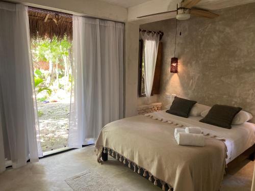 1 dormitorio con cama y ventana grande en VerdeAmar Eco Lodge Jungle Retreat, en Chemuyil