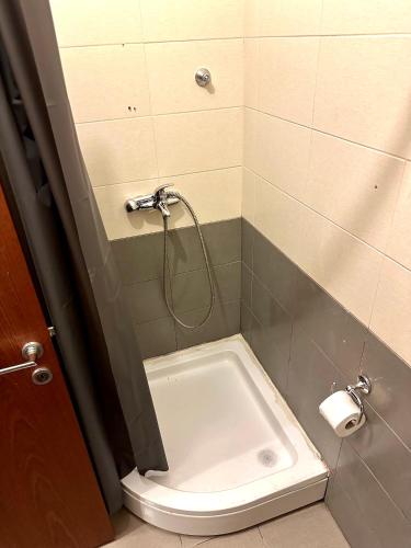 a bathroom with a shower with a white tub at Apartment Stex 3 in Podgorica