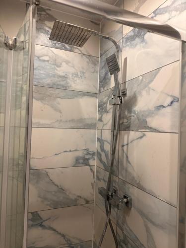 La salle de bains est pourvue d'une douche avec une porte en verre. dans l'établissement Lovely Hillingdon Family Holiday Home - 7 bedrooms, à Ickenham