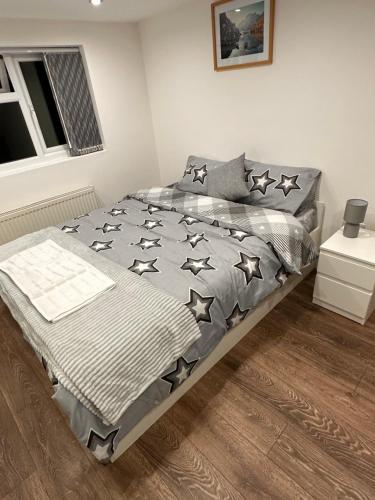 a bedroom with a bed with black stars on it at Lovely Hillingdon Family Holiday Home - 6 bedrooms in Ickenham