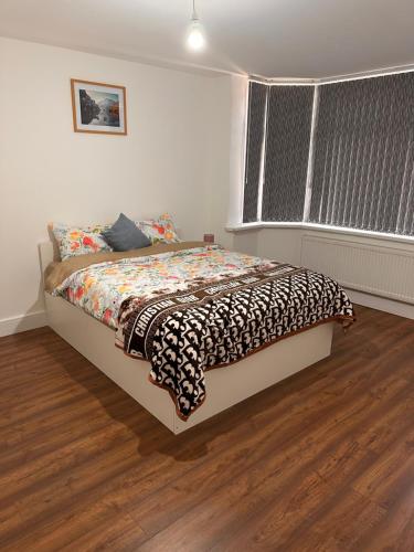 a bedroom with a bed in a room with wood floors at Lovely Hillingdon Family Holiday Home - 6 bedrooms in Ickenham