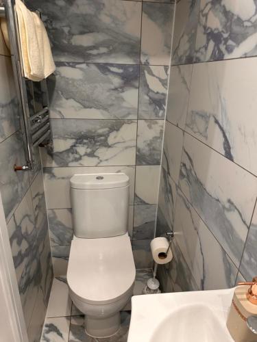 a bathroom with a white toilet and a sink at Lovely Hillingdon Family Holiday Home - 6 bedrooms in Ickenham