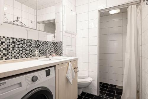 a white bathroom with a washing machine in it at Dinbnb Homes I 4-apartment House in Idyllic Location in Bergen