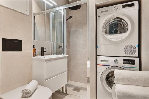 uma casa de banho com uma máquina de lavar roupa e um lavatório em Dinbnb Apartments I New 2023 I 600m to Bryggen em Bergen