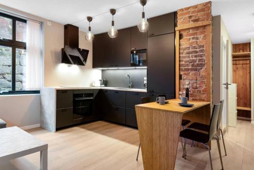 a kitchen with a wooden table and a brick wall at Dinbnb Apartments I New 2021 I Affordable Option in Bergen