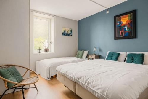 - une chambre avec deux lits, une chaise et une fenêtre dans l'établissement Dinbnb Apartments I Roof Terrace & Laundry in Sandviken, à Bergen