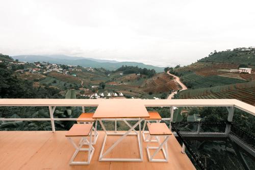 a table and chairs on a balcony with a view at ม่อนชาพาเพลิน ม่อนแจ่ม Monchapaplearn Monjam in Mon Jam