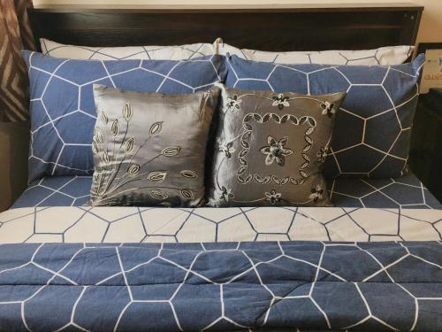 Una cama con almohadas azules y blancas. en Condo , WIFI up to 100mbps , Infinity Pool, en Cebú