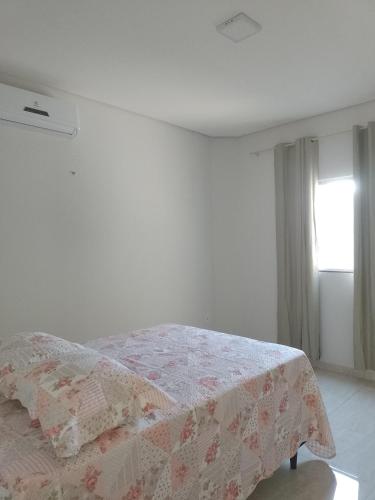 ein Schlafzimmer mit einem Bett mit einer Decke darauf in der Unterkunft Casa de temporada - Raio de luz! in Carolina