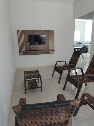 a living room with chairs and a flat screen tv at Casa de temporada - Raio de luz! in Carolina