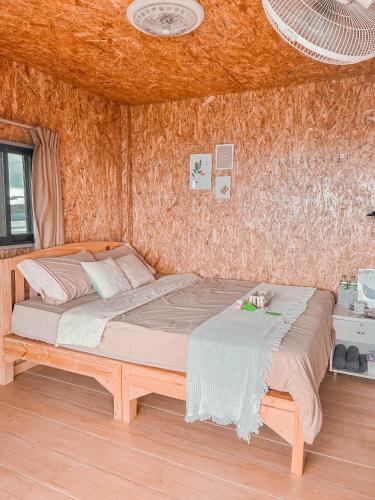a bedroom with a wooden bed in a room at ม่อนชาพาเพลิน ม่อนแจ่ม Monchapaplearn Monjam in Mon Jam