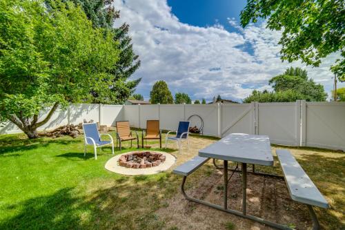 a backyard with a table and chairs and a fire pit at Dog-Friendly Idaho Falls Vacation Rental with Yard! in Idaho Falls