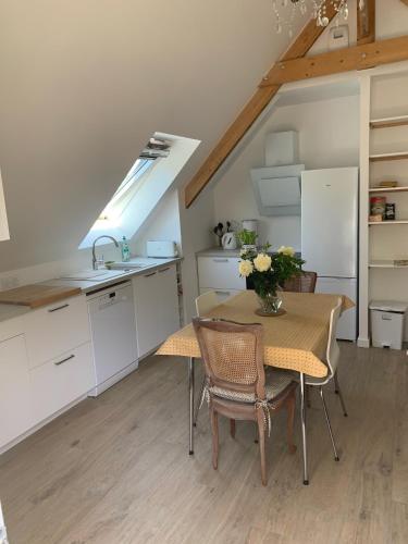 uma cozinha e sala de jantar com mesa e cadeiras em Guest house au calme à 900 M de Longchamps em Saint-Lunaire