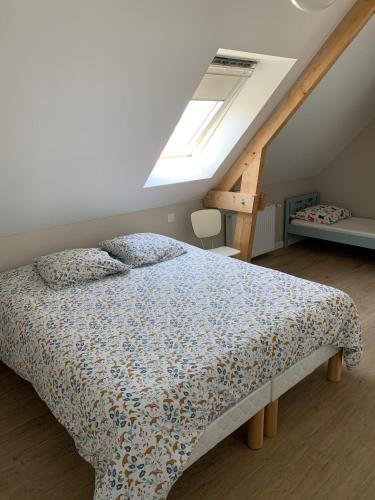 um quarto com uma cama num sótão com uma janela em Guest house au calme à 900 M de Longchamps em Saint-Lunaire