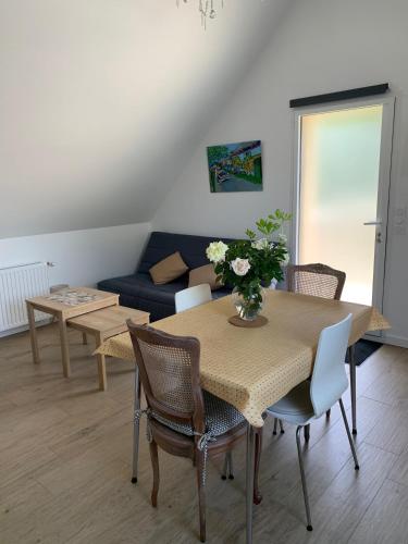 uma sala de estar com uma mesa e cadeiras e um sofá em Guest house au calme à 900 M de Longchamps em Saint-Lunaire