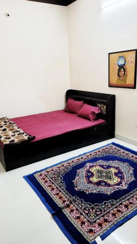 a bedroom with a bed with a rug on the floor at Advaitam in Ujjain