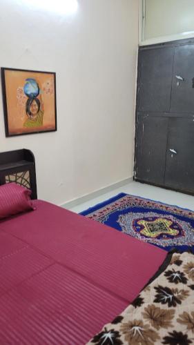 - une chambre avec un lit doté d'un couvre-lit rose dans l'établissement Advaitam, à Ujjain