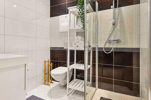 卑爾根的住宿－Dinbnb Apartments I Top-Modern Apartment in Historical Sandviken，一间带卫生间和玻璃淋浴间的浴室