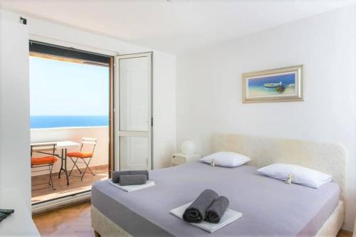 Schlafzimmer mit einem Bett und Meerblick in der Unterkunft Light blue, sea view terrace in Dubrovnik