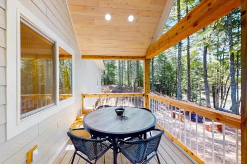 a porch with a table and chairs on it at Chalet on the Bay in Saint Germain