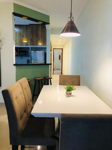 a kitchen and dining room with a white table and chairs at Casa Spar do Atlântico com Piscina in Maricá