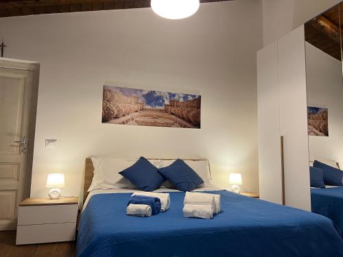 a bedroom with a blue bed with blue pillows at Chiarilu' in Palazzolo Acreide