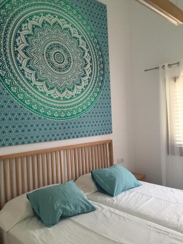 two beds in a bedroom with a large picture on the wall at Los Balandros 216 in Maspalomas