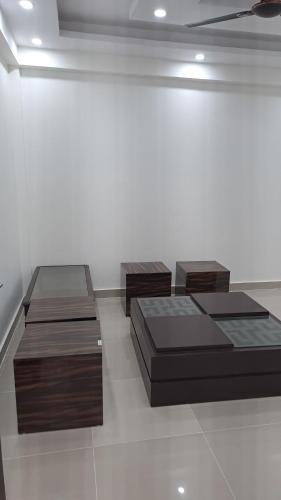 three beds in a room with a white wall at Gokul 2 BHK Entire Flat, Bharat City, Teela Mod, Nr Hindon Airport ,Bhopura , Ghaziabad in Ghaziabad