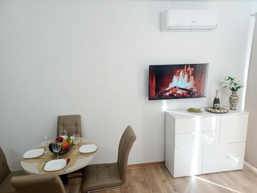 a dining room with a table and chairs and a tv at AJP Gold Szczecin Dąbie in Szczecin