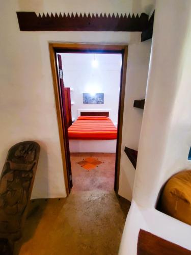 a hallway with a red bed in a room at Reef View Pavilions - Villas & Condos in Lance aux Épines