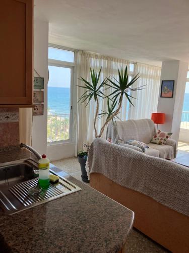 a kitchen with a sink and a living room at Tahiti Dreams in El Campello