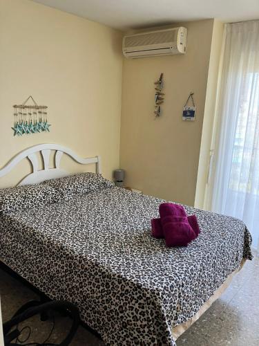 a bedroom with a black and white bed with a purple pillow at Tahiti Dreams in El Campello